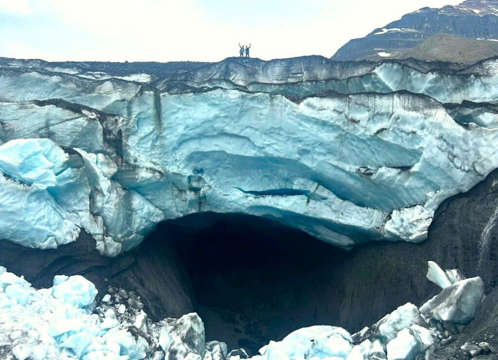 Andy Argo and friend ontop of large ice cave